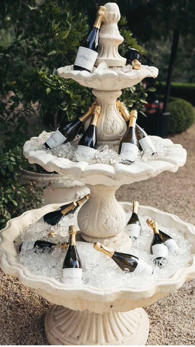 Bottles of champagne on ice in a tiered stone fountain.